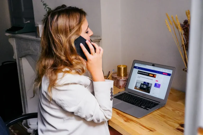 Business owner on the phone at her laptop, illustrating a missed call costing a home service company a new customer